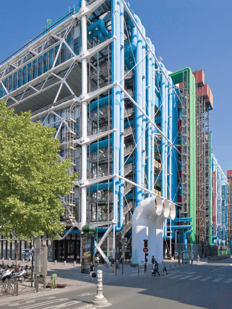 Bright blue and white modern building with innovative architecture, pipes, and scaffolding, showcasing a technological and creative design.
