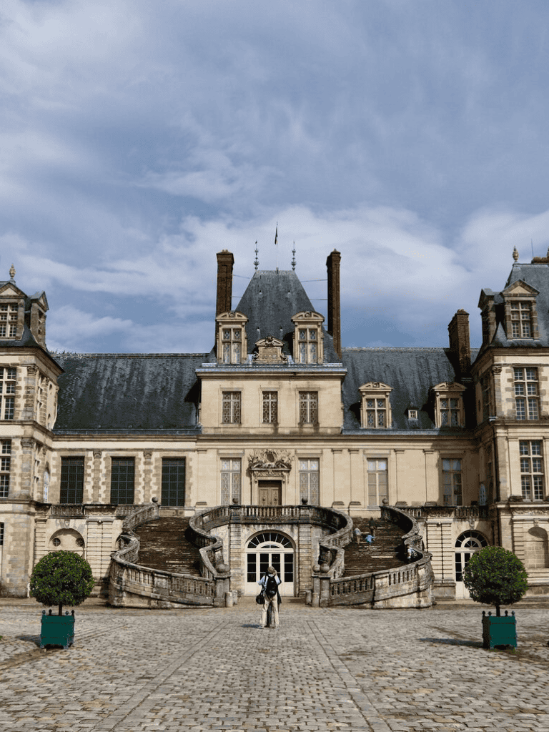 Elegant historic mansion with grand staircase and lush landscaping, perfect for travel and architecture enthusiasts.