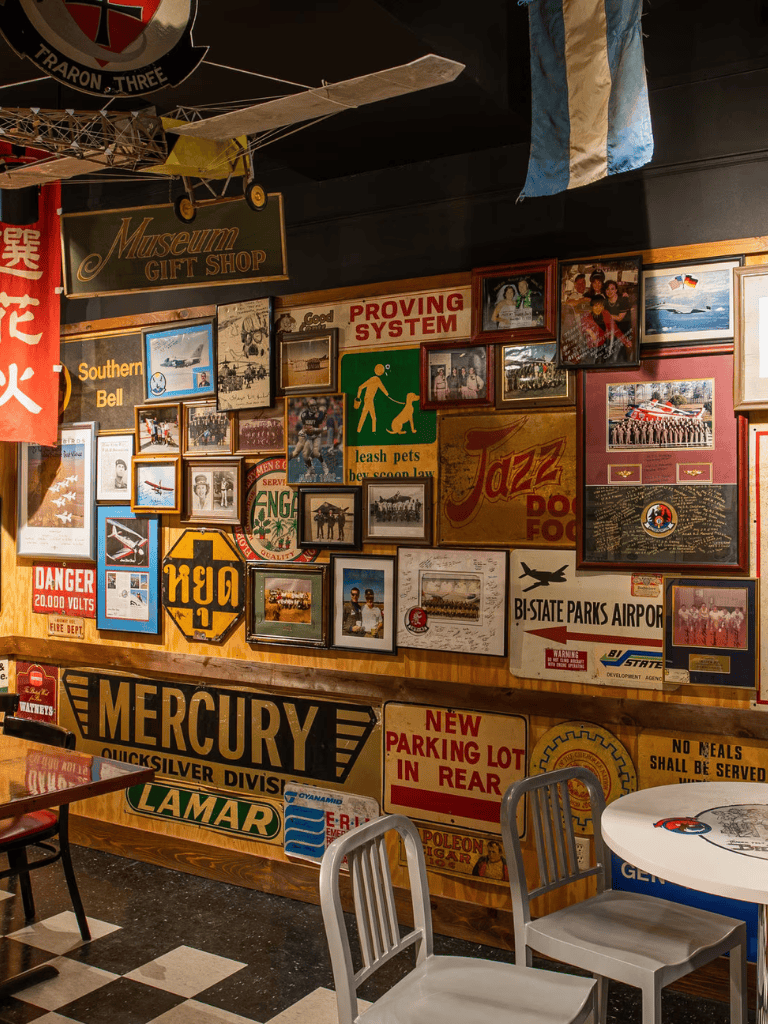 Vintage airport and travel memorabilia wall decor with framed photos and signs.