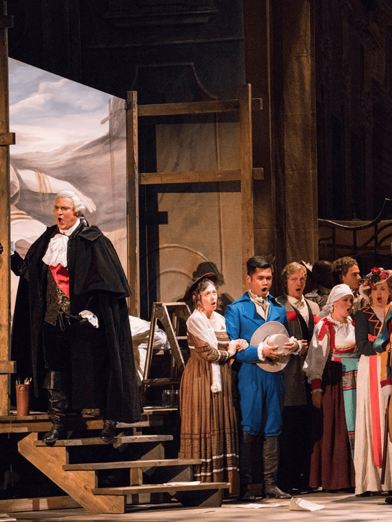 Devilish conductor leading a group of children in a theatrical play about the American Revolution.