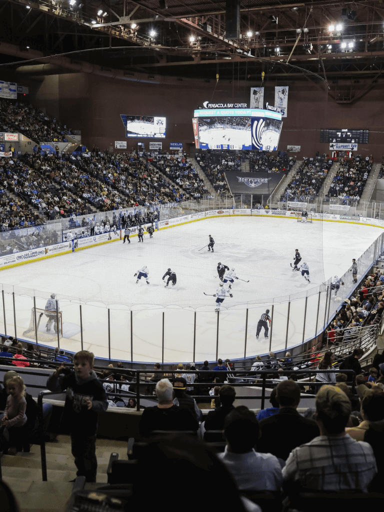 Ice hockey game at Pensacola Bay Center with fans watching action on the ice.