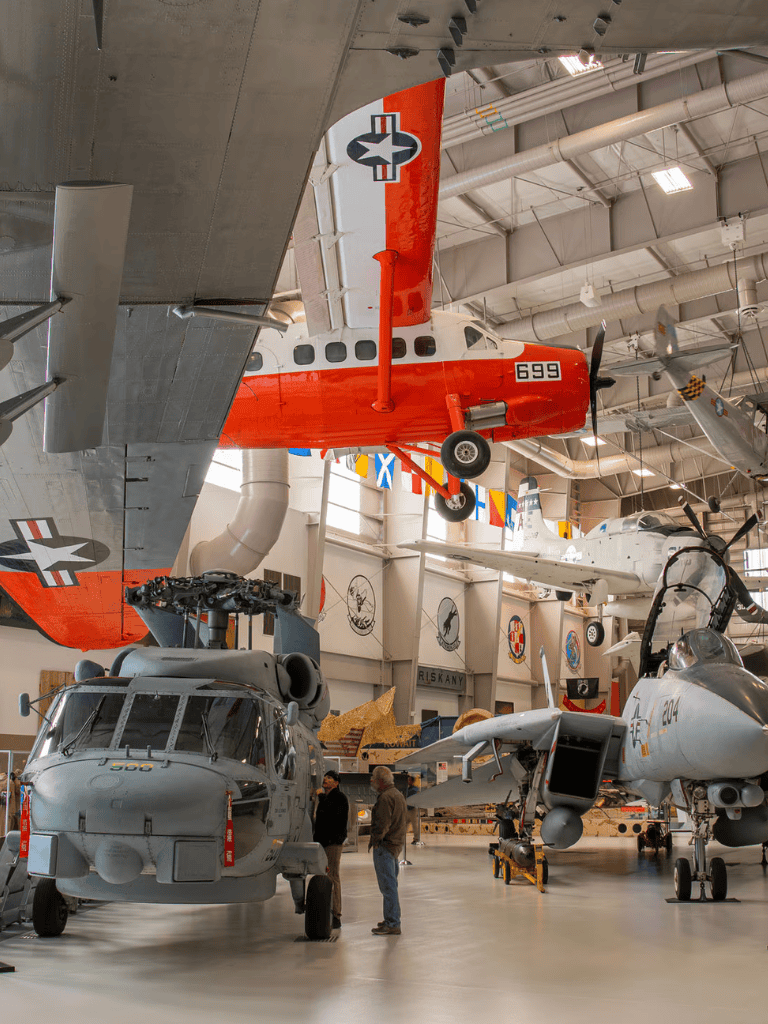 Vintage aircraft museum with military planes and helicopters display.