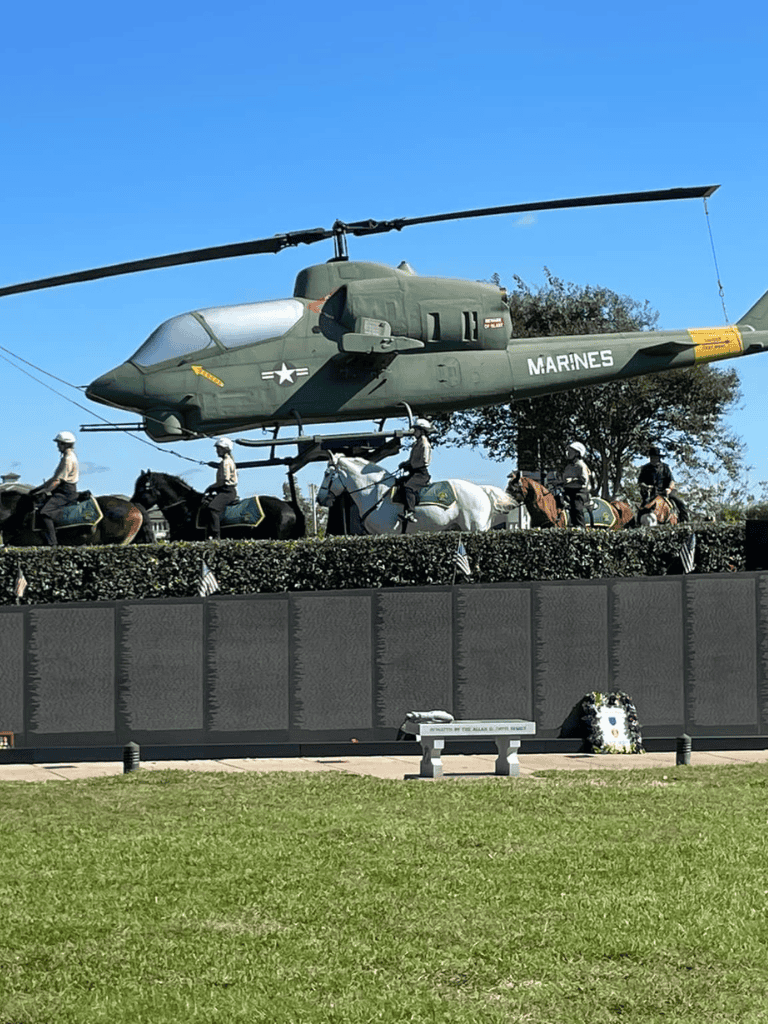 Helicopter and military memorial with horses and soldiers honoring fallen Marines.