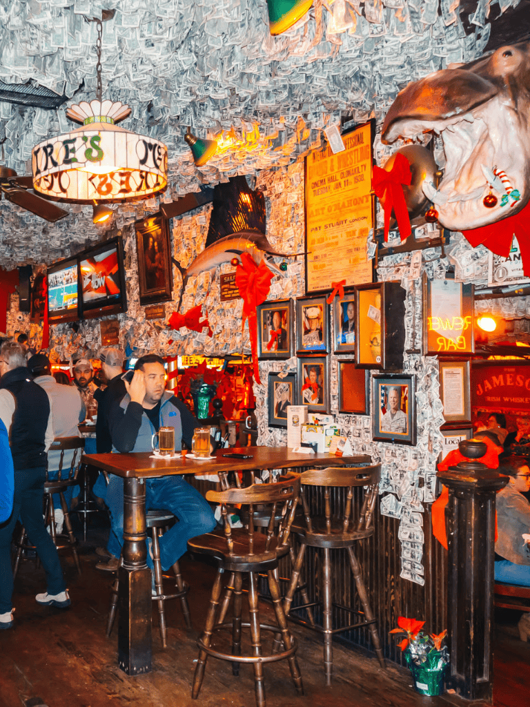 Christmas-themed Irish pub with festive decor, cozy atmosphere, and guests enjoying drinks.