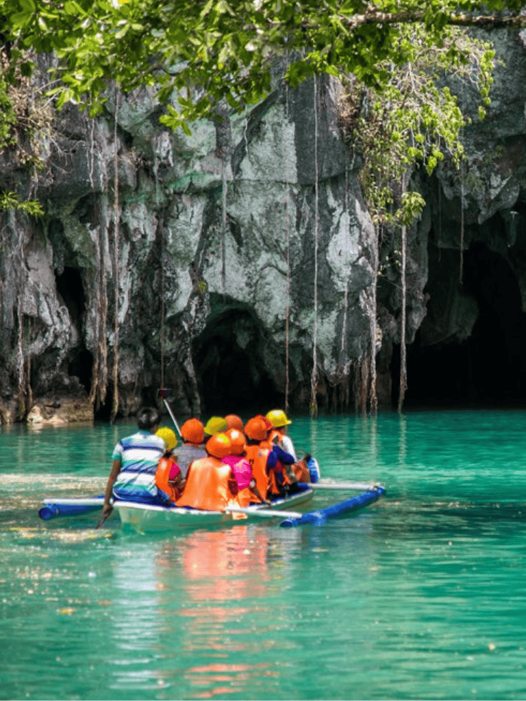 1. group of tourists on a boat near a cave with lush greenery and turquoise water.