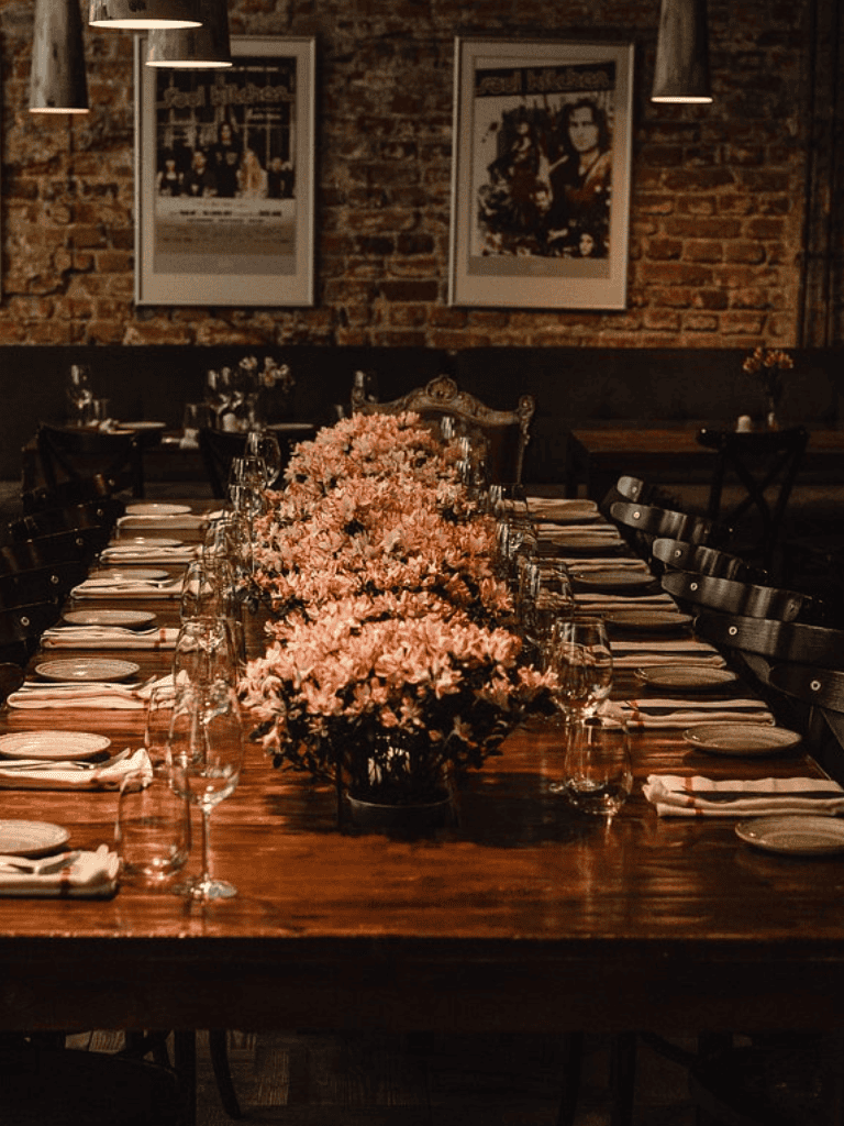 Elegant dining table setup with floral centerpiece and tableware in a cozy restaurant setting.