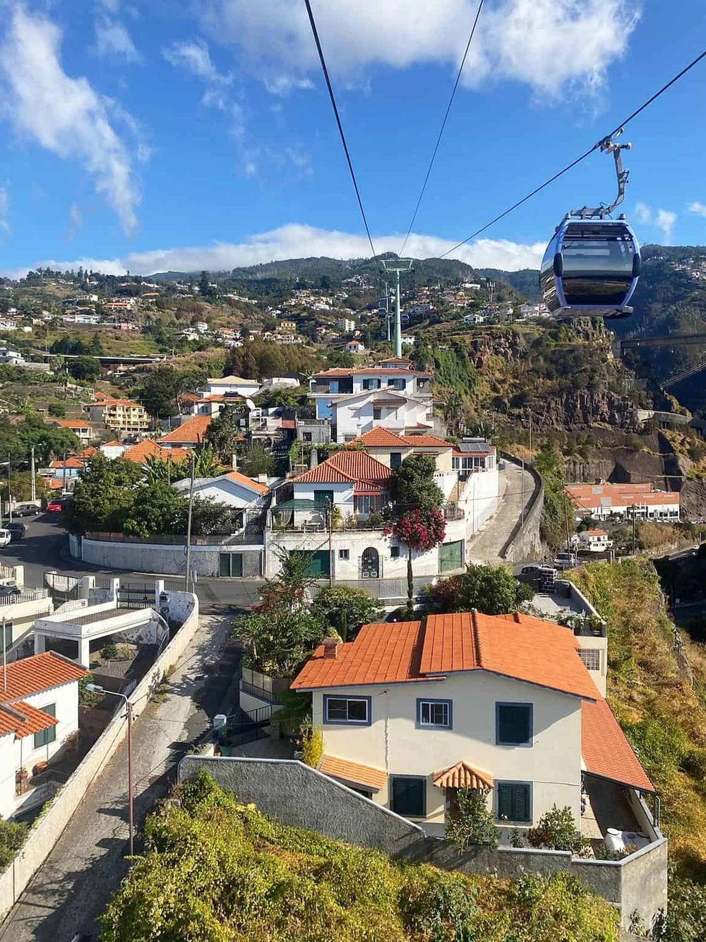Cable car riding over hillside homes in San Francisco, scenic aerial view of vibrant neighborhood.