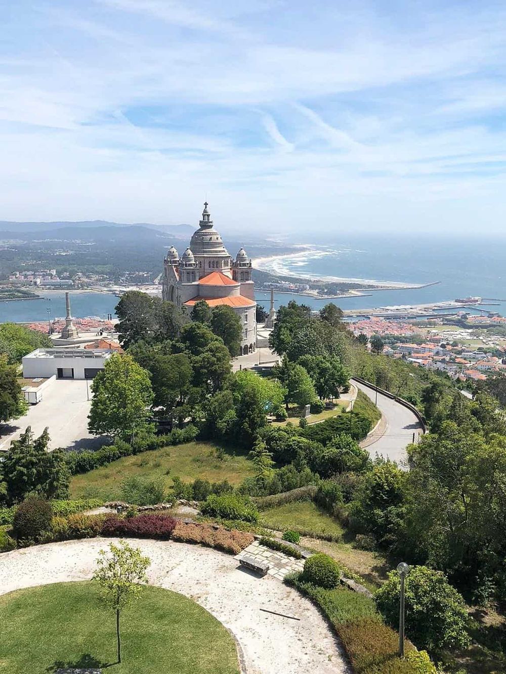 Breathtaking view of the Sacré-Cœur Basilica with scenic landscape and coastal cityscape in the background.