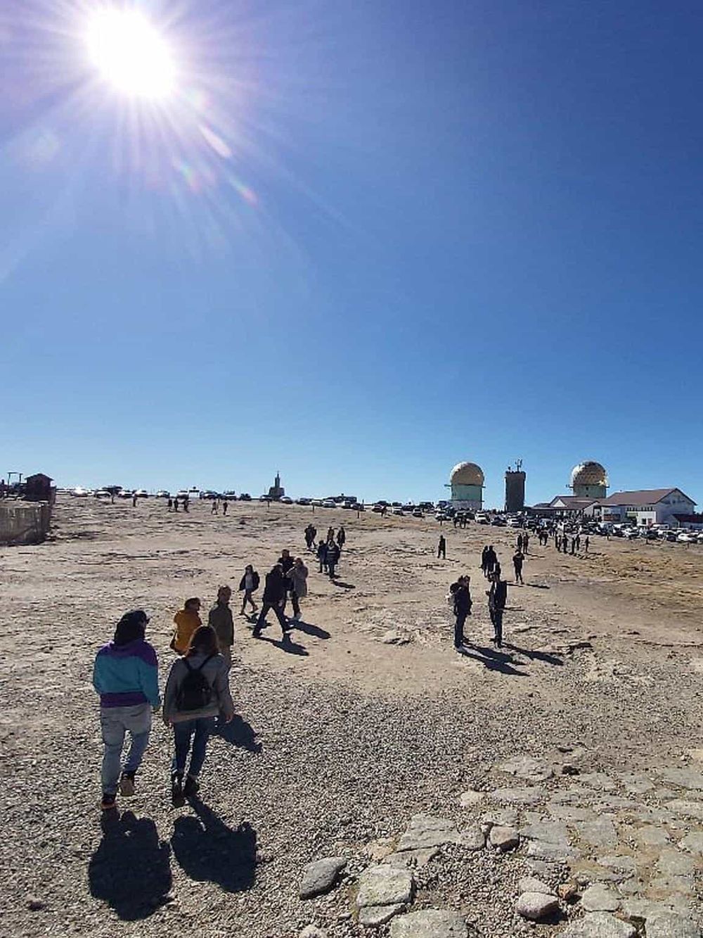 Bright sunny day at the observatory with visitors exploring and gazing at the telescopes. Open sky with clear weather for astronomy enthusiasts.