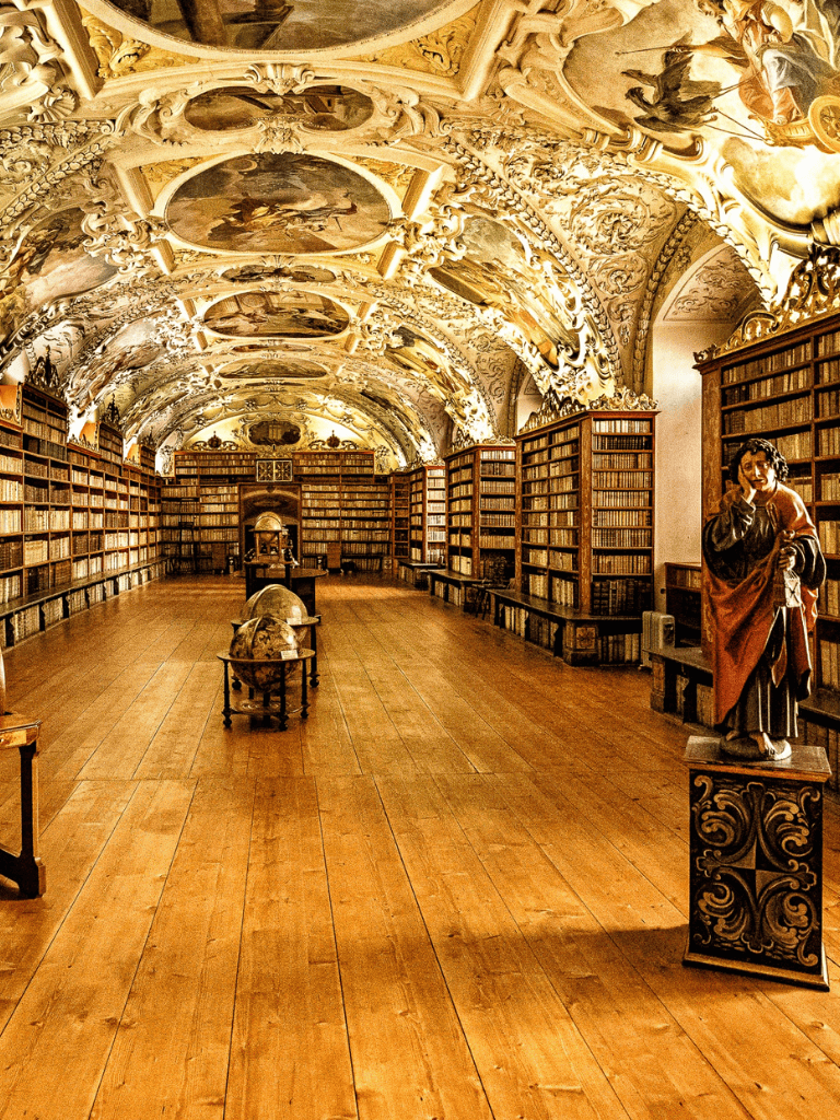Ancient library with ornate ceiling, wooden shelves, and classical sculptures, showcasing historic knowledge and architecture.