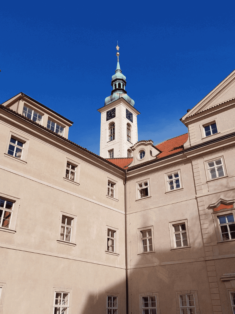 Historic European castle with clock tower and clear blue sky.