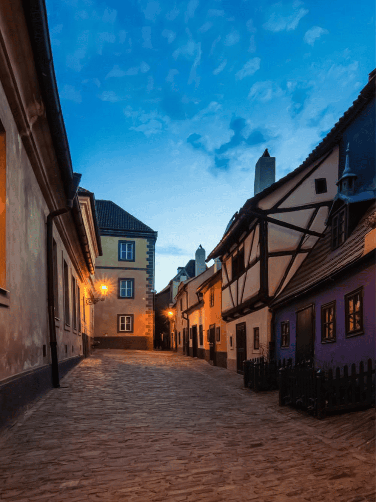 Quiet historic European street with cobblestone pavement and charming old buildings during twilight.