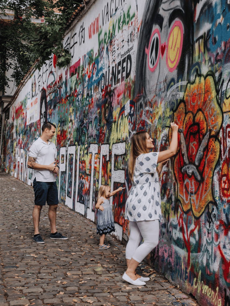 Colorful graffiti mural in an urban setting, family of three enjoying street art.