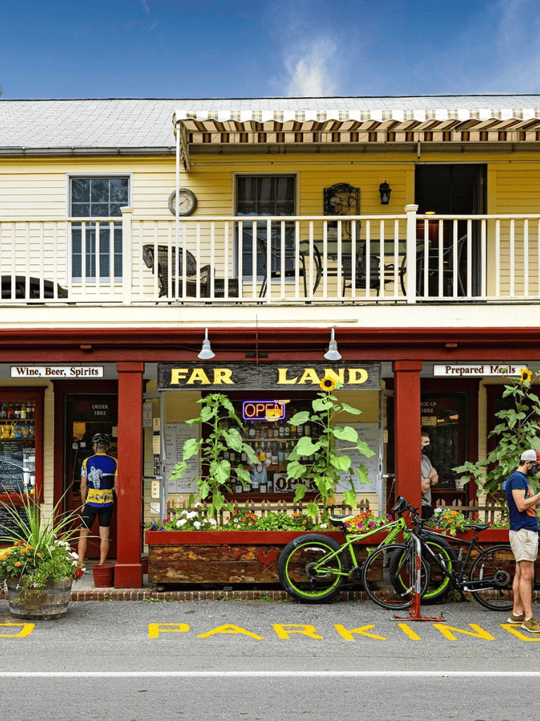 Bike parking outside a cozy store with a "Far Land" sign in a small town, vibrant and inviting.