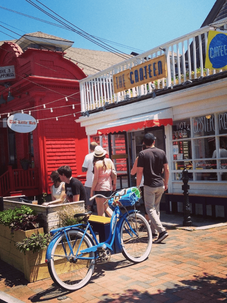 Blue bike parked outside a cozy restaurant, with people enjoying a sunny day. Perfect for exploring local dining spots and outdoor cafes.