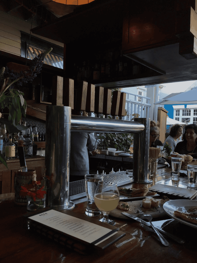 Craft beer tap and cozy dining ambiance at a waterfront restaurant, perfect for food lovers and beer enthusiasts.