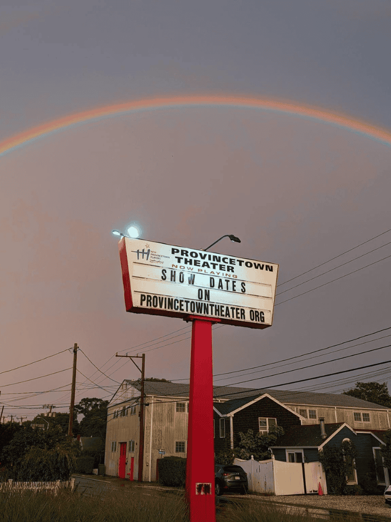 Rainbow over Providence Town Theater marquee with show dates on website.