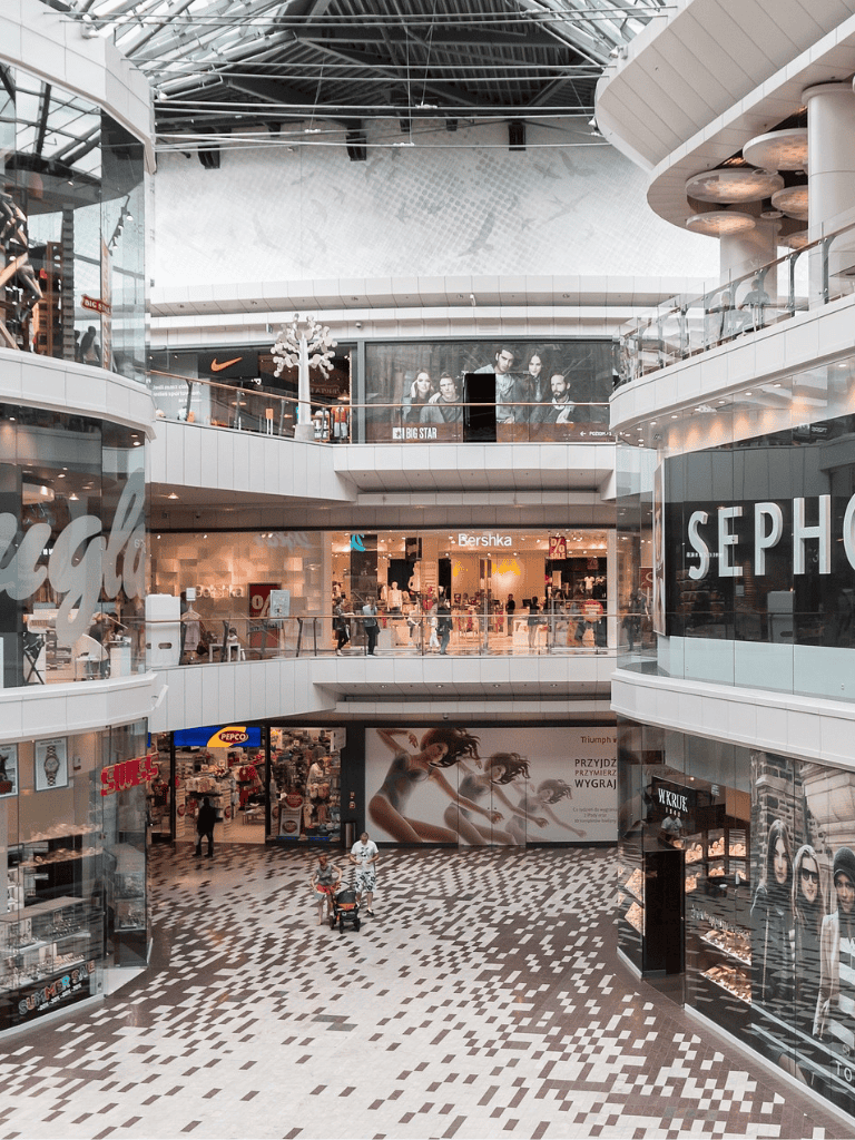 Bright multi-level shopping mall with retail stores and signage at QuestForDirections, an ideal destination for retail therapy.