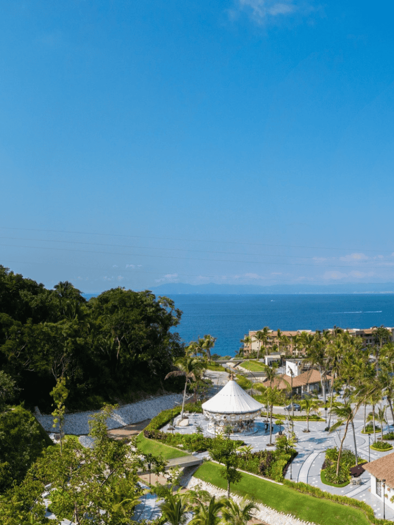 Seaside coastal resort with lush greenery, palm trees, and ocean view, perfect for vacation and relaxation.