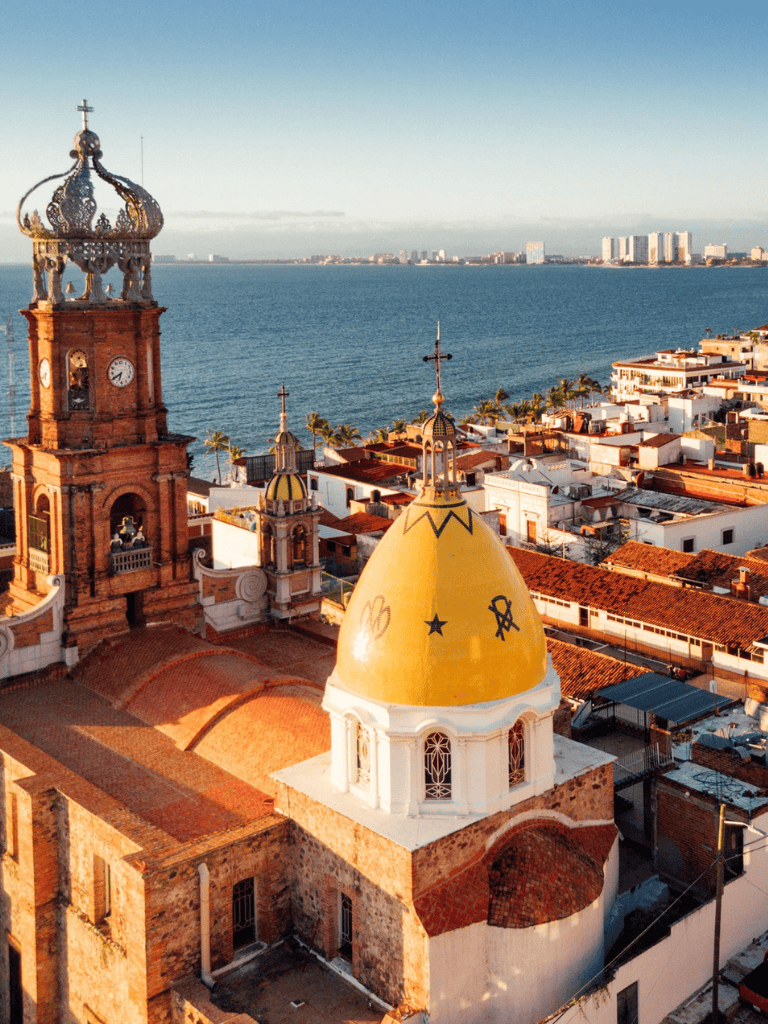 Colorful Mexican church with iconic yellow dome overlooking the city and ocean.