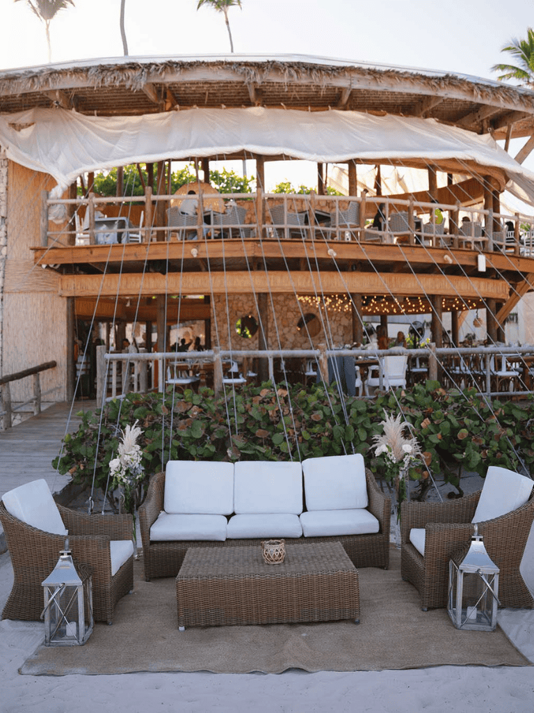 Luxurious beachside restaurant with outdoor seating and tropical decor.