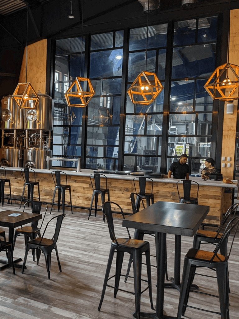 Industrial coffee shop interior with wooden accents and unique geometric pendant lighting.