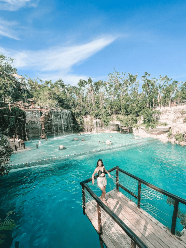 Vibrant outdoor water park with waterfalls, diving pools, and lush greenery for family fun and relaxation.