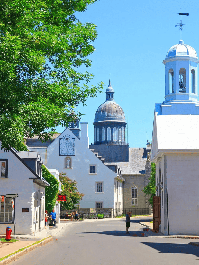 Charming historic European town with white buildings and iconic domed church under blue sky.
