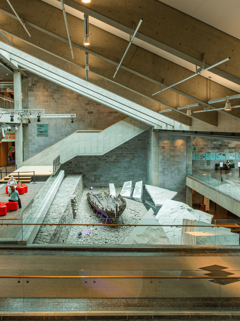 Modern museum interior with historical ship exhibit and informational displays.