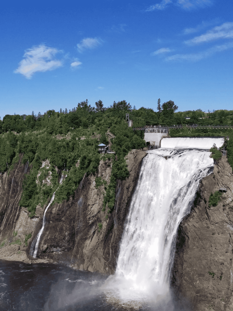Majestic waterfall at Niagara Falls with lush greenery and clear blue sky.