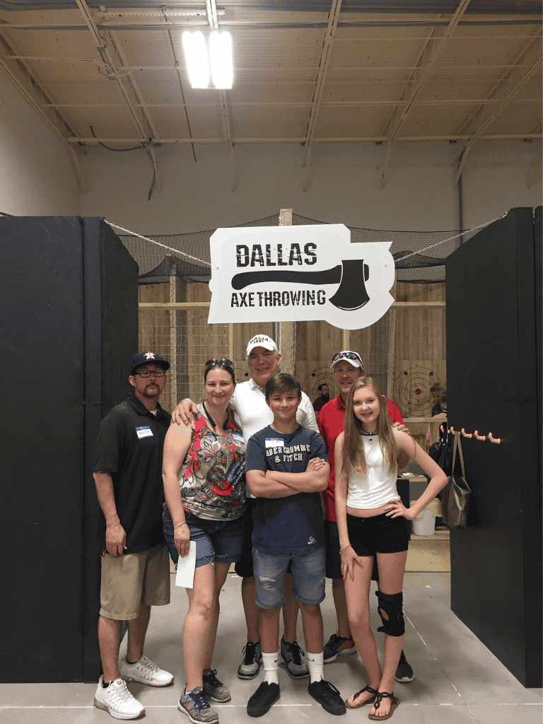 Axe throwing venue with smiling group for family fun and entertainment in Dallas.
