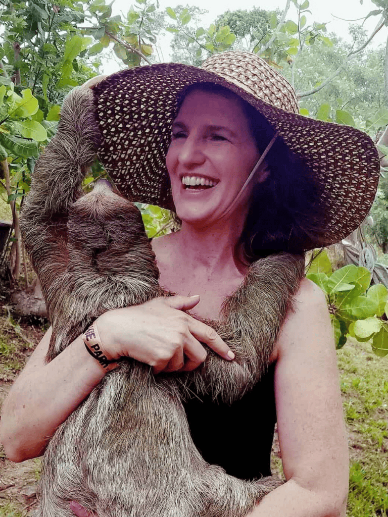 Enchanting woman holding sloth in lush jungle, exploring wildlife in Costa Rica National Park.