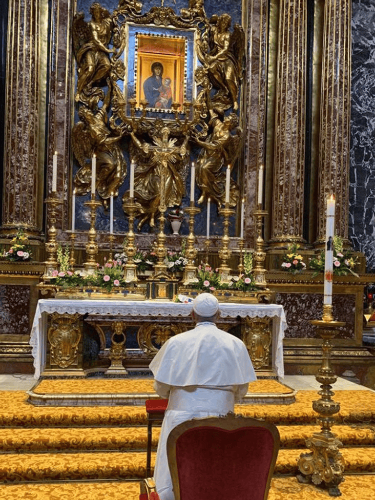 1. Devout man praying before ornate religious altar with gold sculptures and candles.