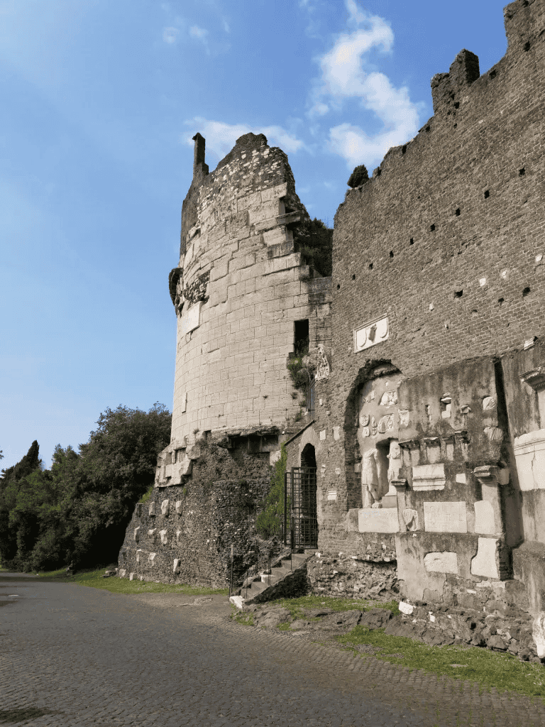 Ancient Roman ruins with stone walls and historical artifacts under a clear blue sky.