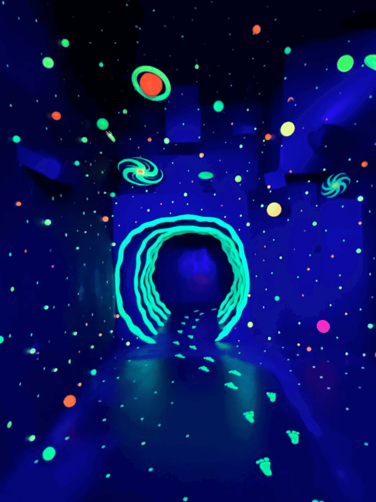 Vibrant neon glow cosmic galaxy tunnel with glowing stars and spirals, immersive blacklight experience for entertainment and fun.