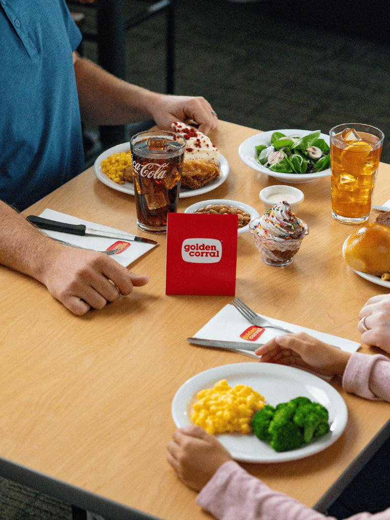 Cheeseburger and sides at Golden Corral restaurant with drinks and salad on the table.