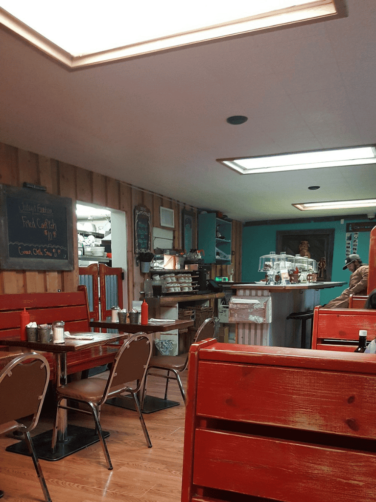 Cozy restaurant interior with wooden furniture and a view of the counter, featuring casual dining atmosphere.