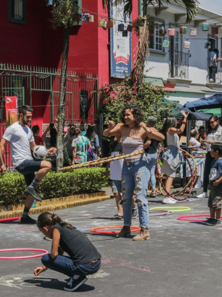 Youth street performance and outdoor activity with colorful hula hoops and children playing.