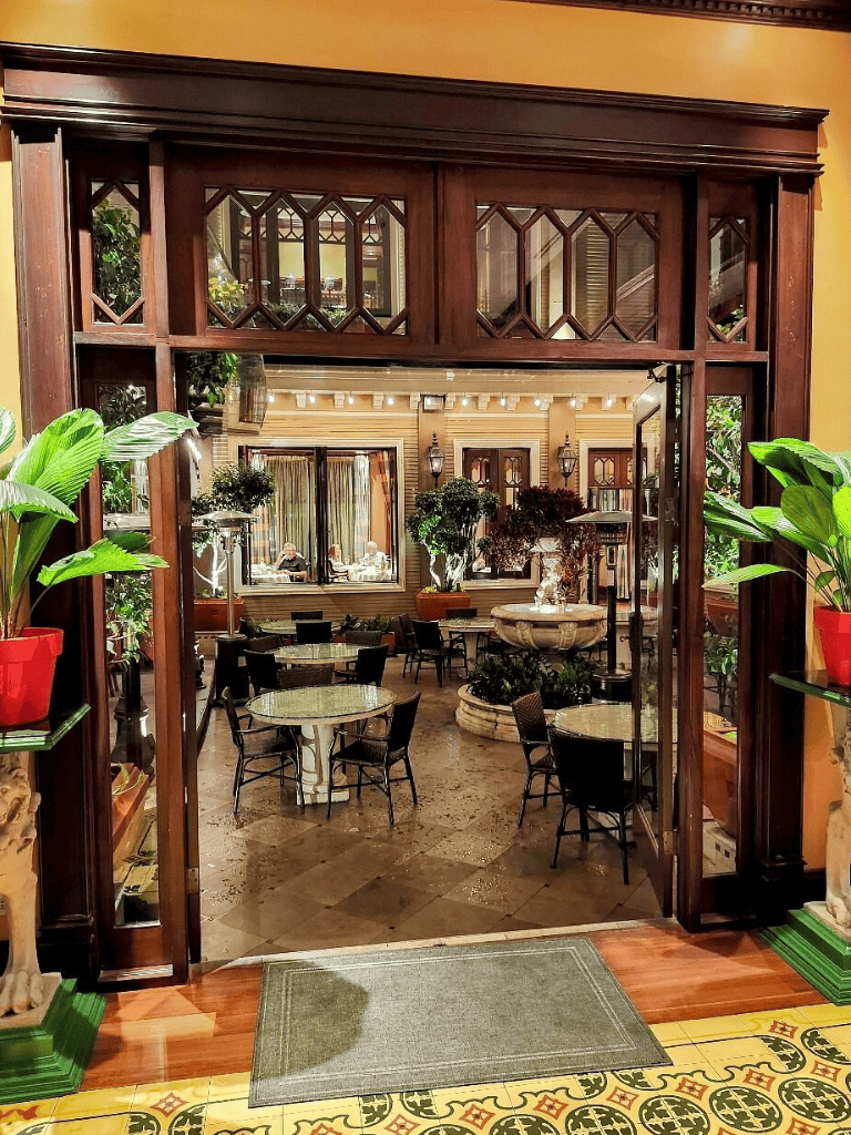 Inviting indoor garden dining area with lush plants and elegant decor, perfect for relaxation and social gatherings.