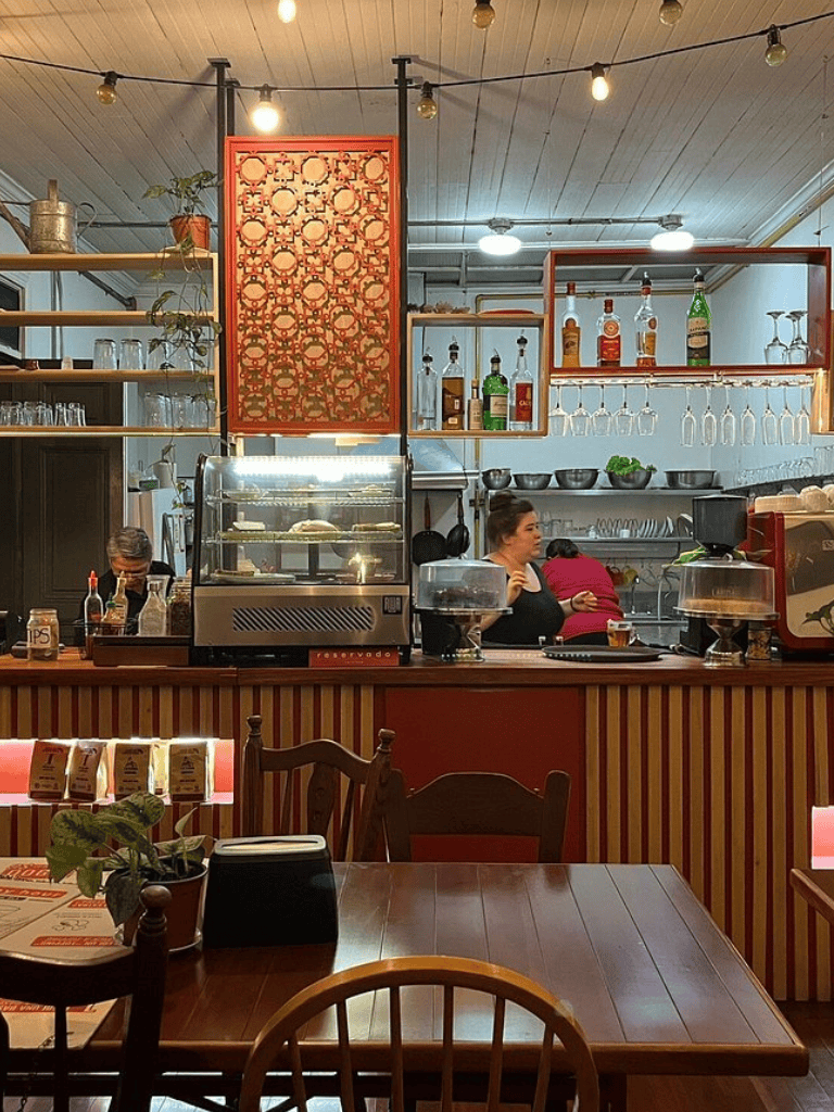 Cozy cafe interior with bar counter, barista, and warm lighting, perfect for relaxed dining experiences.