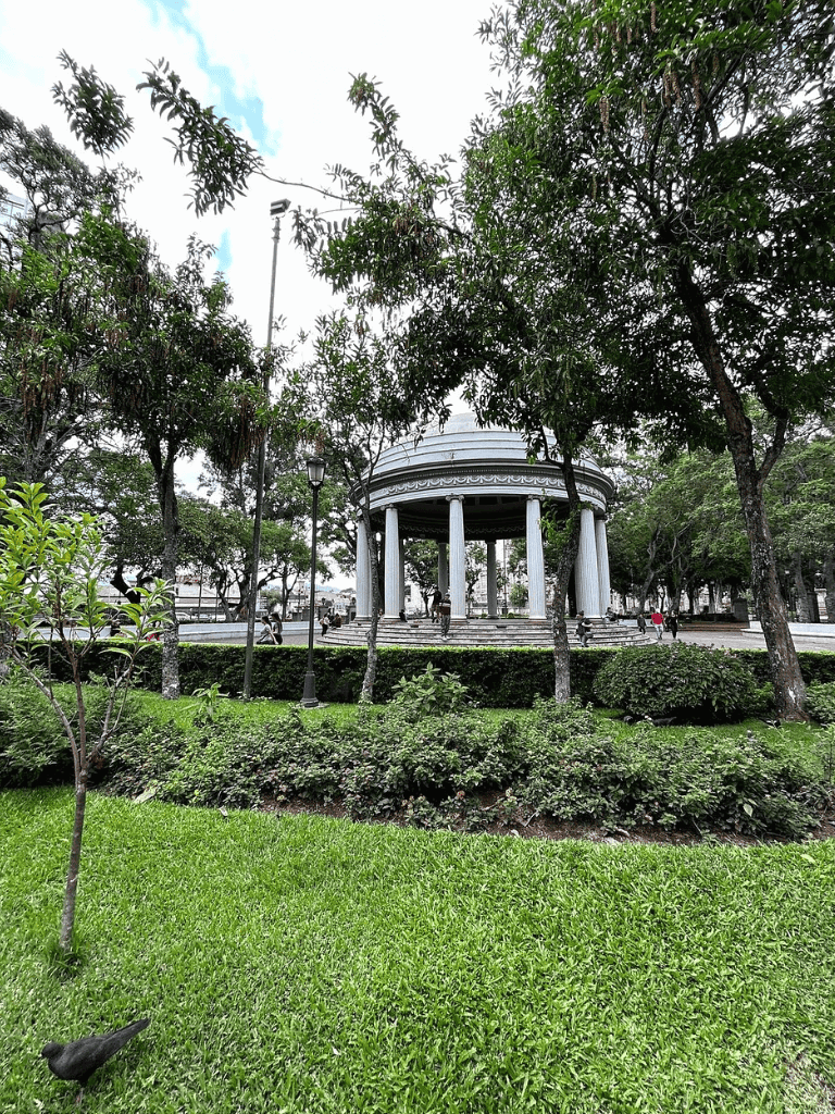 Vibrant park with a classic bandstand, lush greenery, and walking paths for community gatherings.