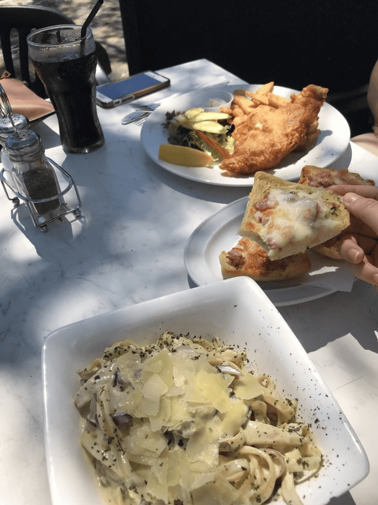 Crispy fish and Italian pasta dishes served at outdoor restaurant.