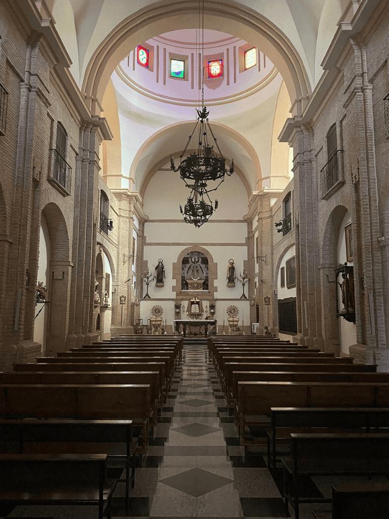 Serene church interior with altar, religious statues, and stained glass windows, ideal for spiritual reflection and worship.