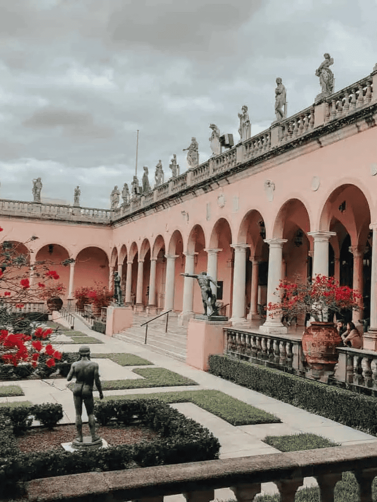 Stone sculptures and classical architecture at a historic European courtyard.