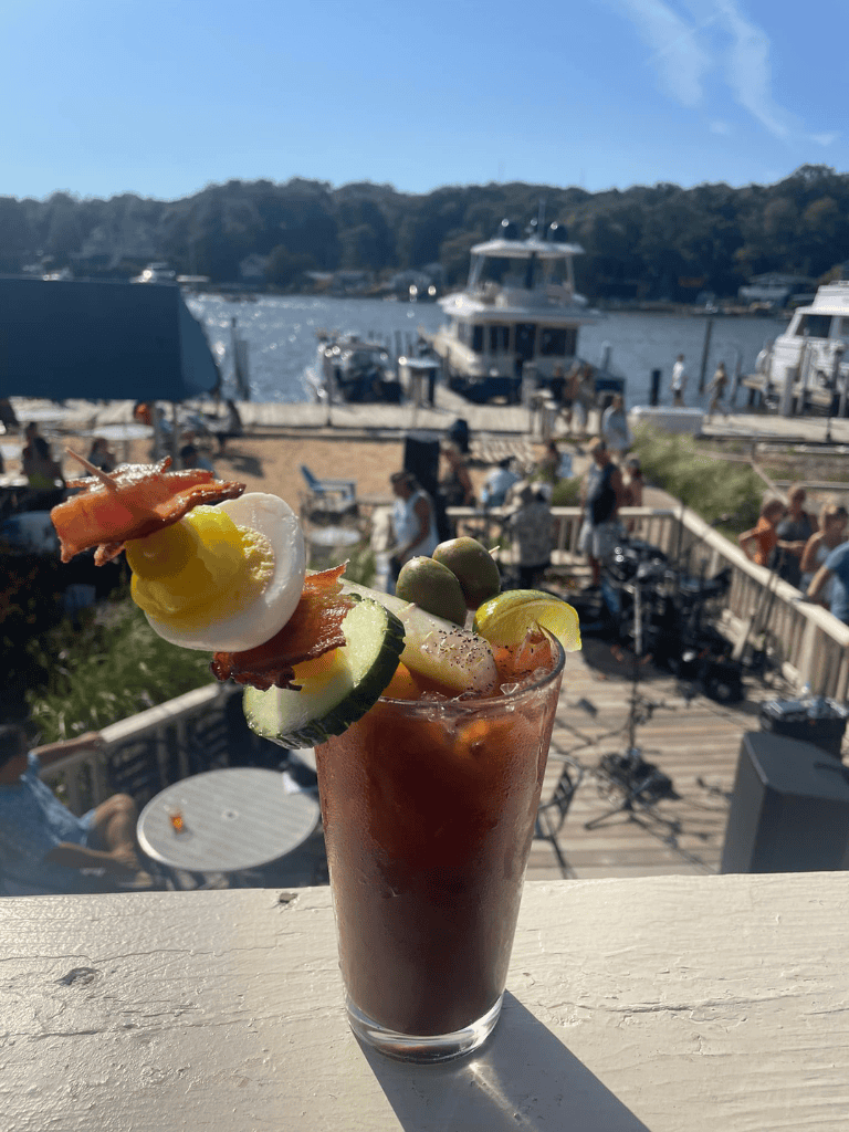 Refreshing Bloody Mary cocktail with garnishes by a marina at QuestForDirections.