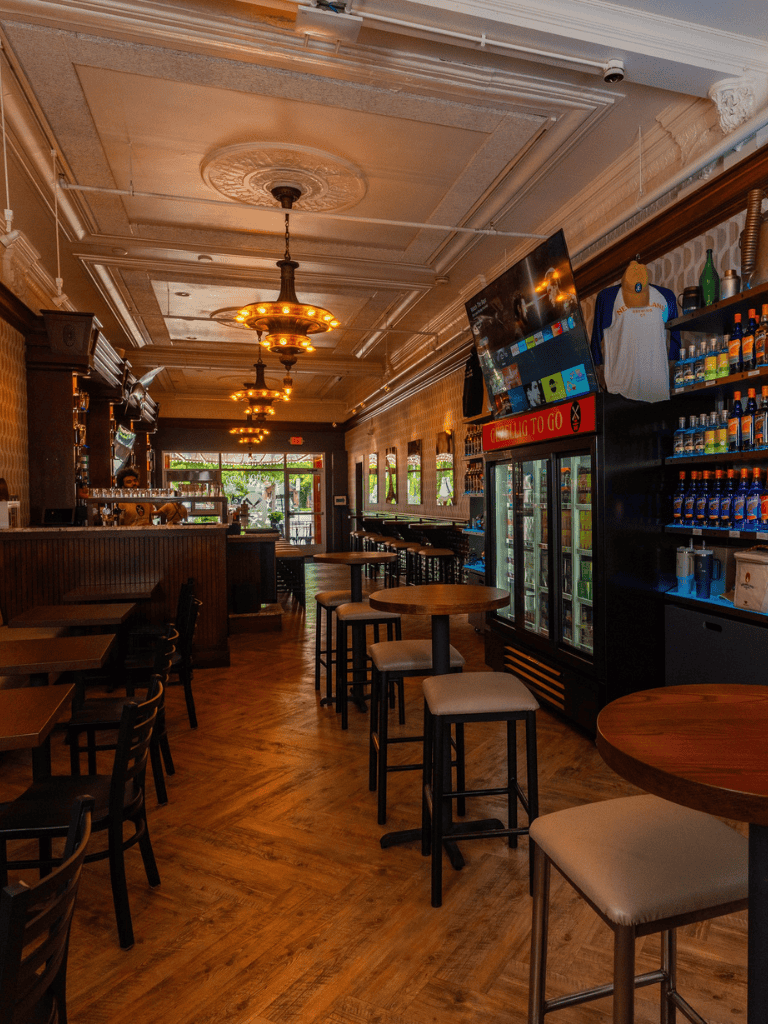 Cozy bar interior with wooden furniture and modern decor, ideal for casual dining and drinks.