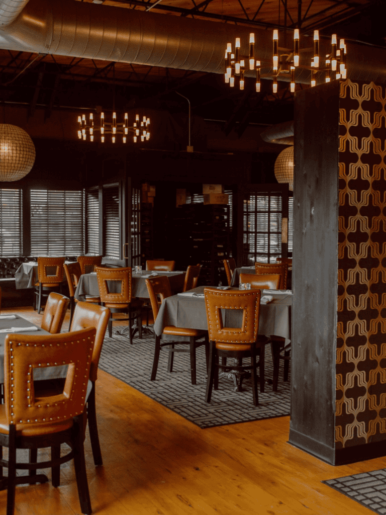 Cozy upscale restaurant interior with warm lighting, wooden furniture, and elegant decor for fine dining.