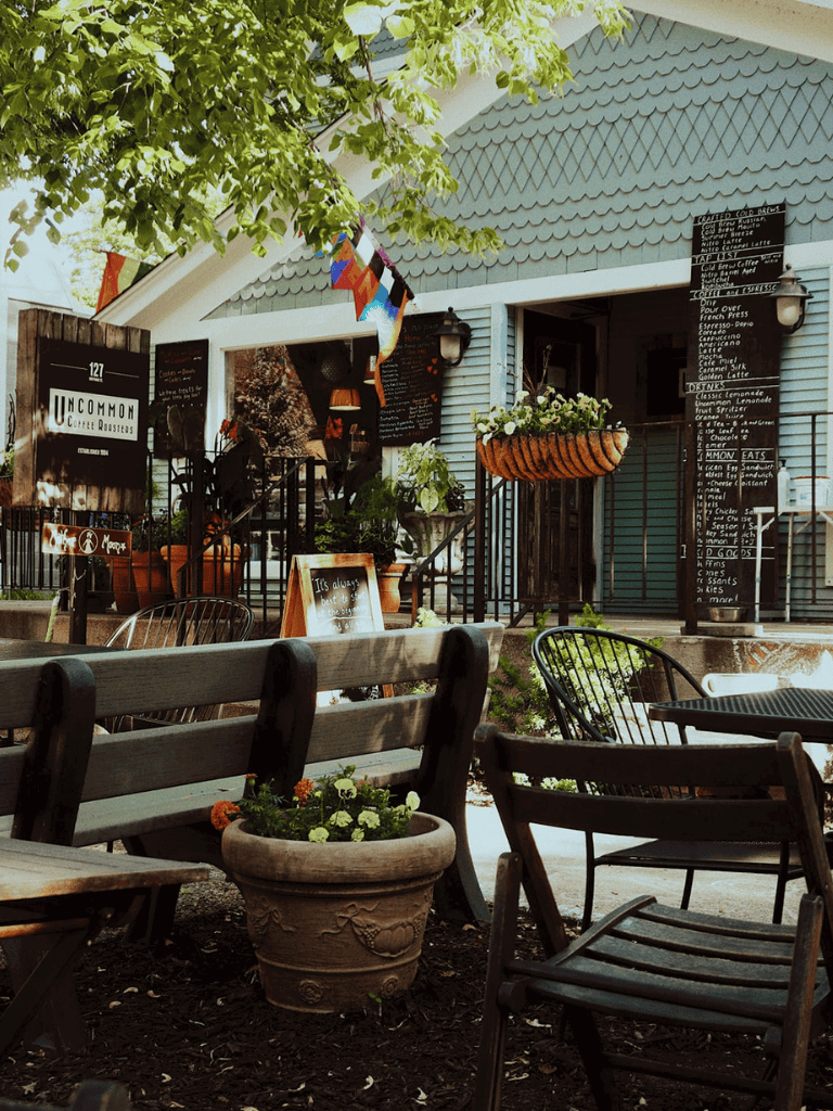 Cozy outdoor cafe at Uncommon Coffee Roasters with charming seating and plant decor.