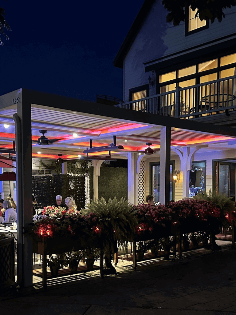 Outdoor dining area at night with string lights and flowers, cozy atmosphere, QuestForDirections restaurant.