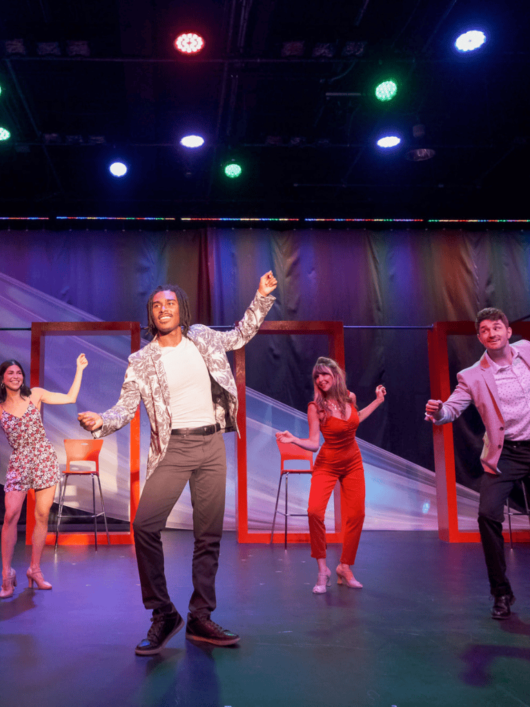 Joyful actors performing on stage at QuestForDirections comedy event, vibrant lighting, lively entertainment, and diverse cast, engaging audience.